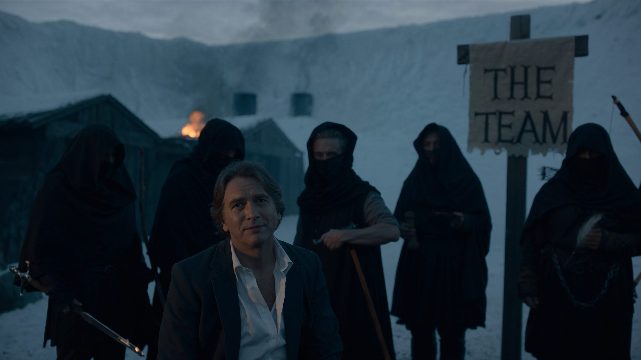 Operator in the inner yard of Castle Black with five hooded Night's Watch silhouettes behind. THE TEAM banner.